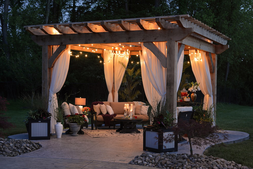 A pergola with warm lights and cozy seating