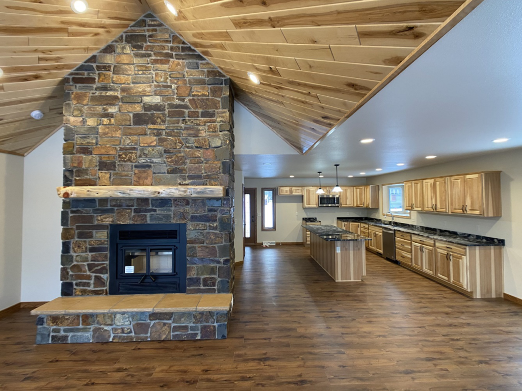 A house interior with a fireplace and a kitchen on one side