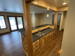 A new home construction with a kitchen with a small sink, cabinets, countertop, etc.