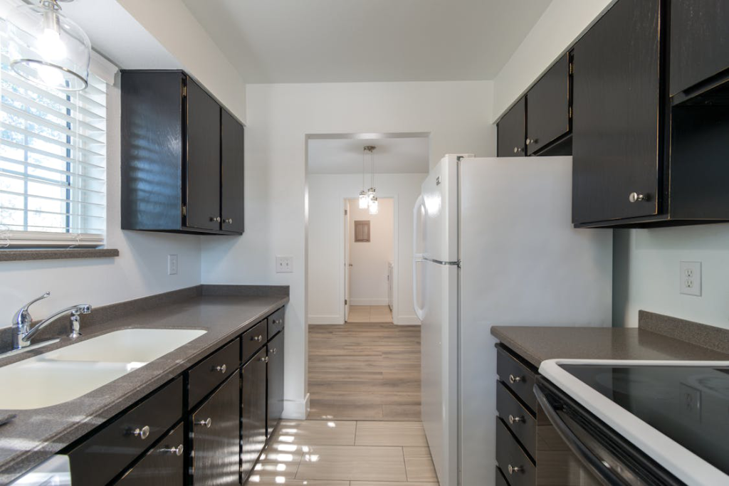 A remodeled kitchen with black cabinets and dark countertops