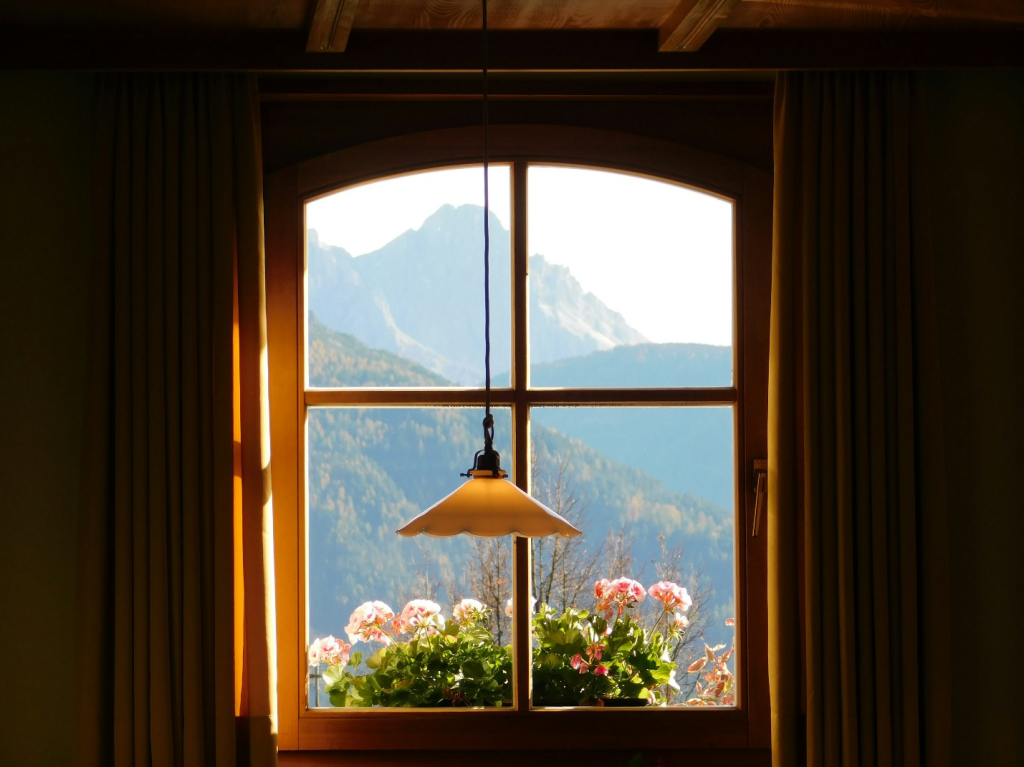 A lamp hanging next to a window.