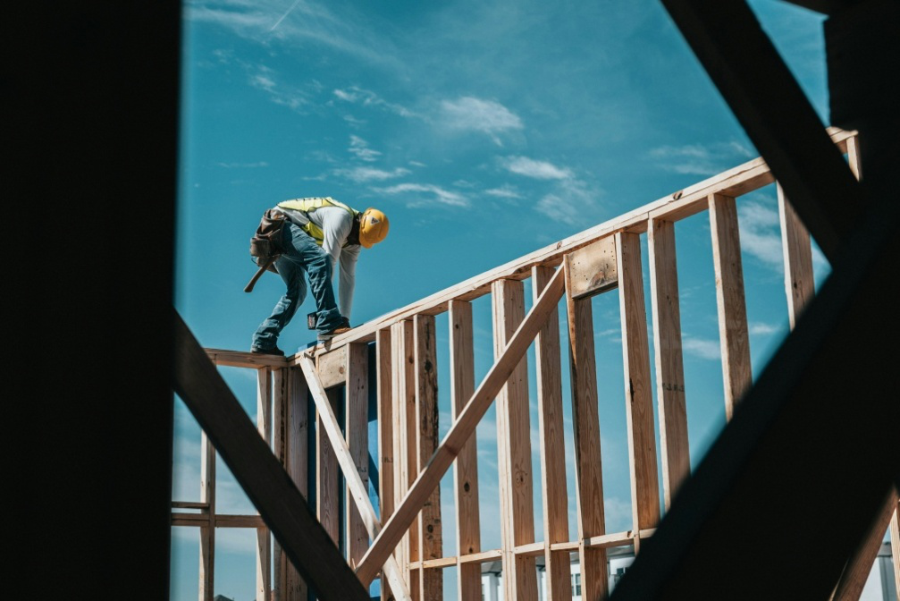 Worker framing a new home, demonstrating teamwork in residential construction