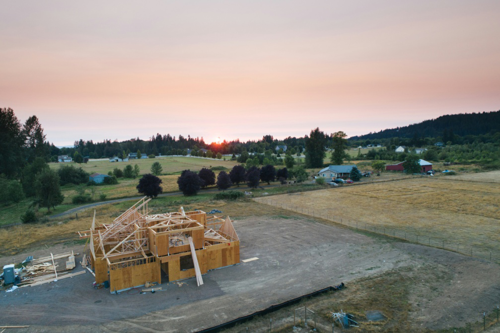 Image alt text: A residential home under construction, featuring framing and foundation work