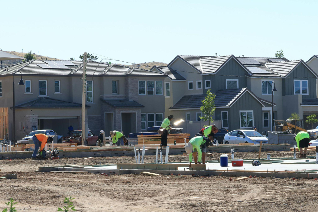 Construction workers collaborating on-site for a new home construction project.