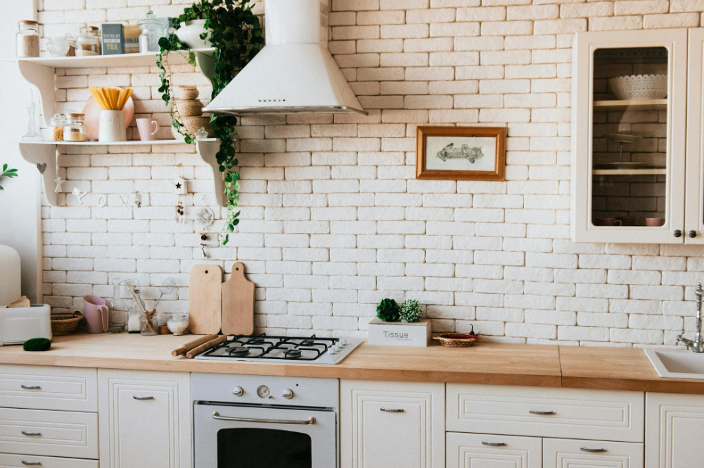 Farmhouse-style kitchen with white brick walls and wooden countertops.